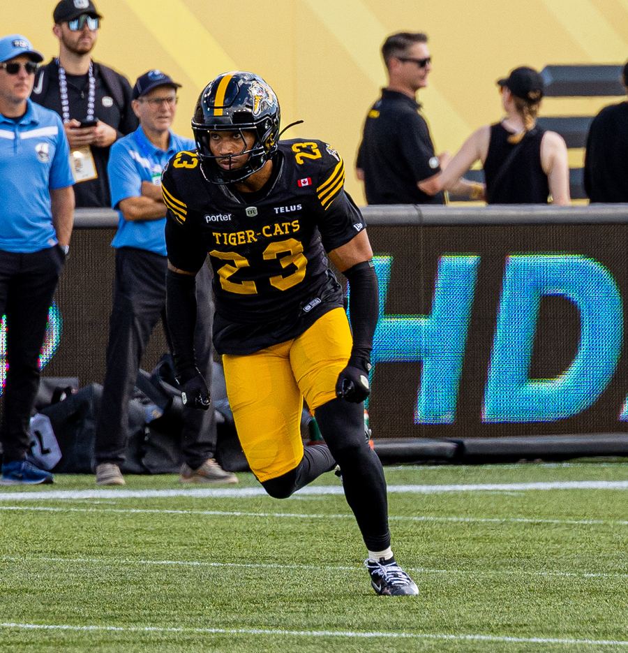 Devynn in the Tiger-Cats black and gold #23 uniform, dropping into coverage